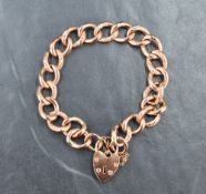 A 9ct rose gold curb link bracelet with alternating engraved and plain links, with heart padlock,