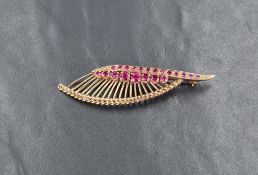 A 9ct gold ruby spray brooch, the linear set round cut rubies with gold spray motif and braided