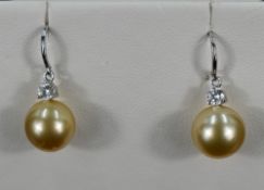 A pair of gold coloured cultured pearl earrings with diamond detail on 18ct white gold loop drops,