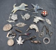 A small vintage jewellery box containing a selection of silver and white metal brooches including