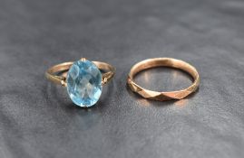 A 9ct rose gold wedding band having facet detail and another ring having blue paste oval gem stone