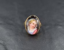 A 9ct gold ceramic cameo ring, the bezel set ceramic portrait depicting a maiden, having split