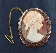 A shell cameo depicting a maiden in profile wearing a head scarf, within a rose metal mount with