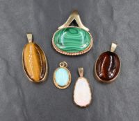An assortment of semi-precious cabochon pendants, all set in yellow metal having no marks, including