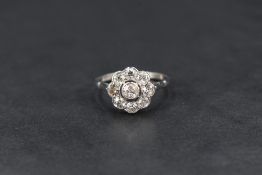 An Edwardian diamond cluster ring of daisy flower design, the central old cut diamond measuring