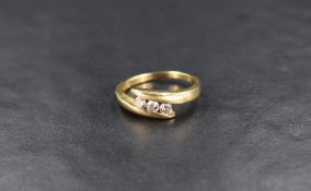 An 18ct gold diamond trilogy ring, the three round brilliant cut diamonds measuring approximately