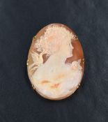 A yellow metal shell cameo brooch, possibly marked 18ct, depicting a lady in profile with a bird and