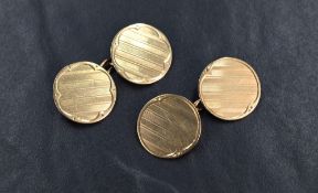 A matched pair of 9ct gold cufflinks, the panels of circular form with plain borders and central