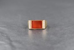 A carnelian and diamond signet style ring, the central rectangular carnelian flanked by four