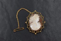 A yellow metal shell cameo brooch, depicting Demeter in a bezel setting with decorative openwork