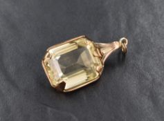 A rectangular citrine pendant in a yellow metal mount, the stone having been repurposed as bares a