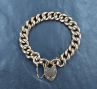 A rose metal curb link bracelet, marked 9c having a heart padlock and safety chain, approximately