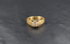 An 18ct gold diamond gypsy style ring, the central cushion style cut diamond in a claw setting,