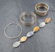 Three silver bangles of various forms and an artisan made white metal bracelet stamped silver having