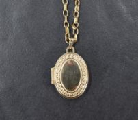 A 9ct gold locket, the oval locket having a decorative meander border, on a 9ct gold belcher