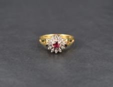 A ruby and diamond cluster ring, the central round cut ruby measuring approximately 0.20ct, with a