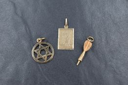 Three 9ct gold charms or pendants, comprising ones depicting St Christopher, a dart and a Star of