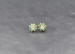 A pair of yellow metal emerald and cubic zirconia stud earrings, the central cubic zirconia with