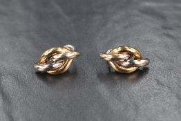 A pair of 9ct gold two-tone stud earrings, of a twisted knot motif, 3.2g. Non-matching backs.