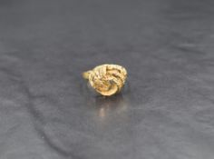 A high carat yellow gold ring, of a textured knot motif with a 9ct gold ring size reducer, ring size