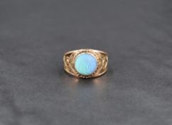 An opal ring, the circular opal cabochon having a matt finish and set in a collared mount within a
