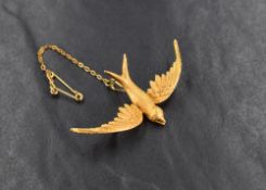 A yellow metal swallow bird brooch, marked 15ct having feather detail engraving with safety pin, 4.