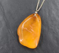 A rough cut amber pendant with white metal fitting and silver chain approx 18' & 13.5g total