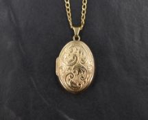 A 9ct gold oval locket, having decorative scroll work to the front, on a 9ct gold curb link chain,