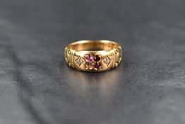 An 18ct gold gypsy style ring, having a central quad of round cut rubies and possibly garnets,