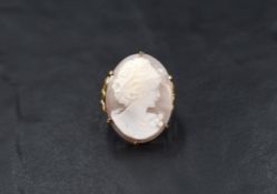 A 9ct shell cameo ring, the claw set cameo depicting a lady in profile, having decorative scroll