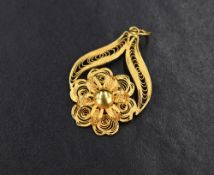 A high carat gold filigree floral motif pendant, the central flower flanked by two scrolls, 2.3g