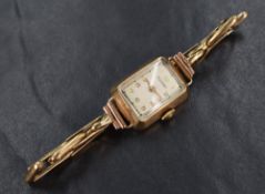 A 9ct gold Rotary wristwatch, the rectangular white dial having Arabic numerals, on a 9ct gold