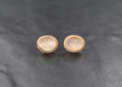 A pair of 9ct gold stud earrings having clear cabouchon stones in collared twist wire mounts