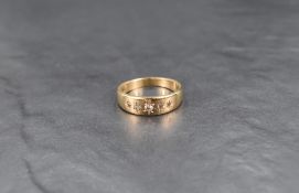 A yellow metal gypsy ring stamped 9ct having five inset graduated diamond chips, size R/S & approx