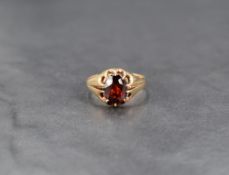 A garnet set gypsy ring, having a central oval cut garnet with moulded shoulders, on a yellow