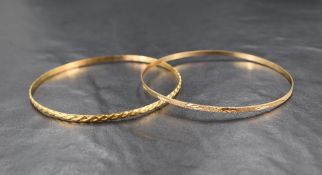 An 18ct gold bangle, having an embossed rope motif, sold along with a 9ct gold bangle, having a