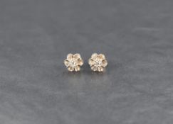 A pair of diamond chip set stud earrings in claw set decorative floral style mounts, no marks but