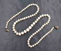 A string of white graduated baroque pearls with a white metal clasp, approx 22.5 inches