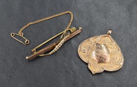 A 9ct rose gold medalion with presentation inscription dated 1921 and a 9ct rose gold bar brooch