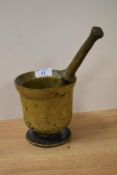 An early solid brass mortar and pestle with banded design, the footed mortar measuring 13cm high