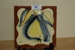 A 20th Century terracotta tile, illustrated with an abstract pear design against a brown/cream
