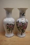 A pair of large decorative vases, hand painted in an oriental style with a striking peonies design