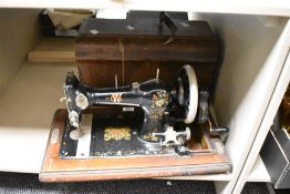A hand cranked CWS Federation sewing machine, mounted on a mahogany base