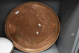 A large Victorian hand beaten copper tray of circular form with pie crust edge, measuring 60cm in
