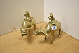 A pair of 20th Century Eastern brass buffalo and rider studies, each measuring 18cm long