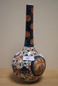 A 19th Century Japanese Imari bottle vase, decorated in typical blue and red colours against a cream