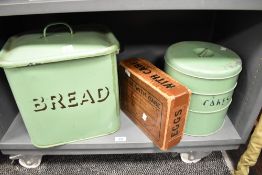 A mid-20th Century green enamelled bread bin, measuring 36cm high, together with an enamelled cake
