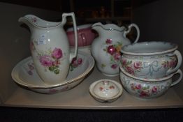 A toilet jug and bowl together with four chamber pots and a soap dish mostly having floral