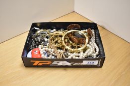 A selection of vintage costume jewellery, to include strings of faux pearls, a planished copper