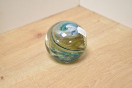 A 20th Century glass paperweight, designed by Michael Harris, with internal swirl design,